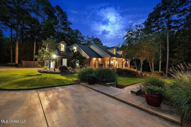 view of front of property featuring brick siding and a lawn