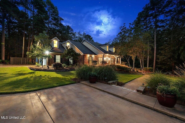 view of front facade with a lawn and brick siding
