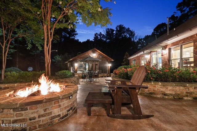 patio at twilight featuring outdoor dining area and an outdoor fire pit