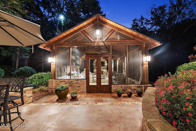 exterior entry at night with a patio area and french doors