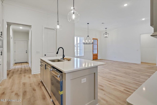 121 Ashby Ridge Dr, Canton, MS 39046 - kitchen featuring stainless steel dishwasher, a sink, light wood-style floors, a kitchen island with sink, and light countertops