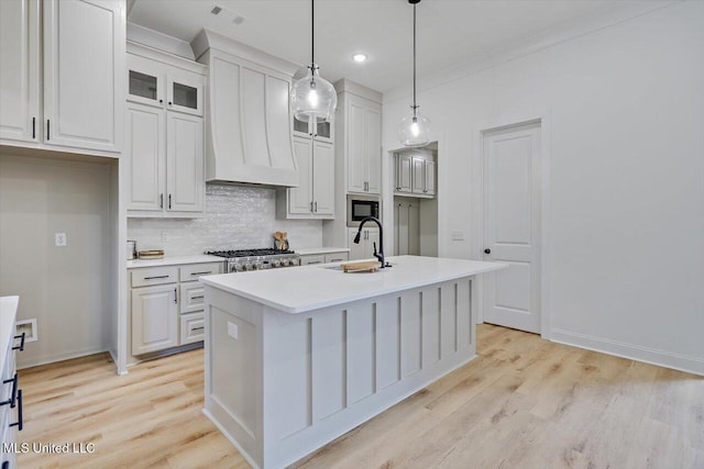 121 Ashby Ridge Dr, Canton, MS 39046 - kitchen featuring a sink, premium range hood, built in microwave, backsplash, and light countertops