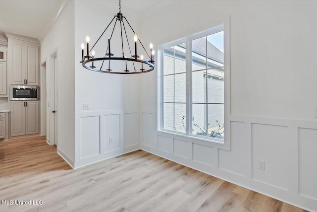 121 Ashby Ridge Dr, Canton, MS 39046 - unfurnished dining area featuring a decorative wall, a chandelier, light wood-style floors, and wainscoting