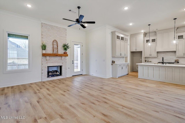 121 Ashby Ridge Dr, Canton, MS 39046 - unfurnished living room with light wood-style flooring, crown molding, baseboards, ceiling fan, and recessed lighting