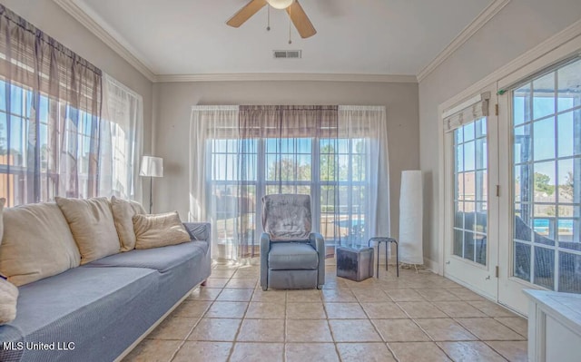 tiled living room featuring ornamental molding, ceiling fan, and a wealth of natural light