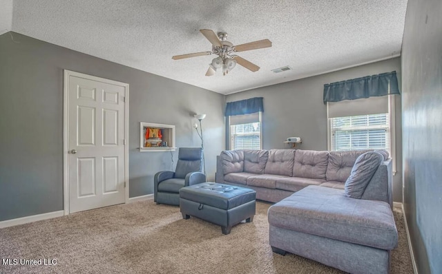 carpeted living room featuring a textured ceiling, ceiling fan, and a wealth of natural light