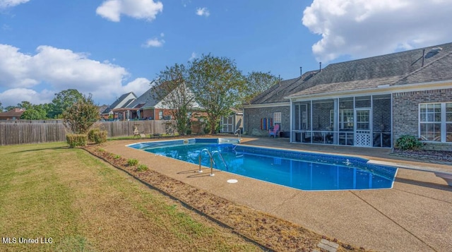 view of swimming pool with a diving board, a yard, a sunroom, and a patio