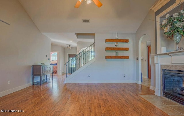 unfurnished living room featuring a fireplace, light wood-type flooring, and ceiling fan