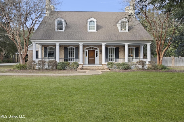 cape cod-style house featuring covered porch and a front lawn