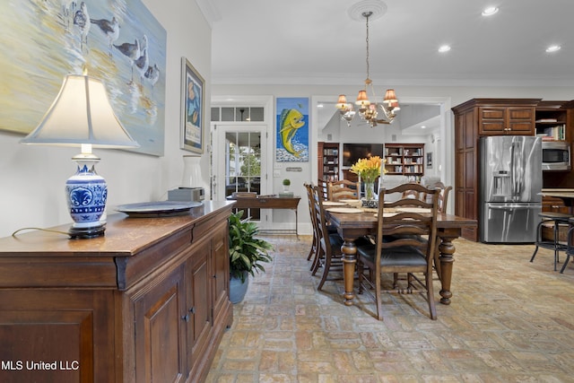 dining space with a notable chandelier and crown molding