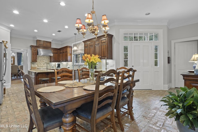 dining space with ornamental molding and an inviting chandelier