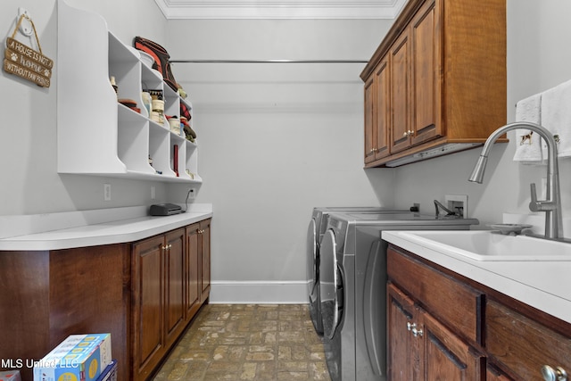 laundry area with cabinets, washing machine and dryer, sink, and crown molding