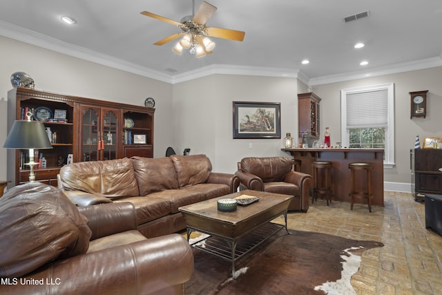 living room featuring bar, crown molding, and ceiling fan