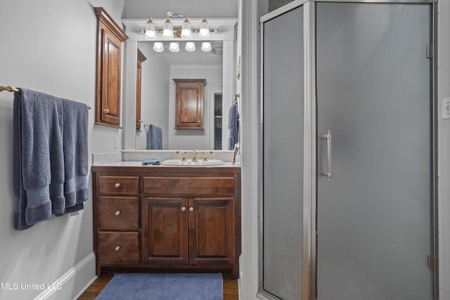 bathroom with hardwood / wood-style flooring, vanity, crown molding, and walk in shower