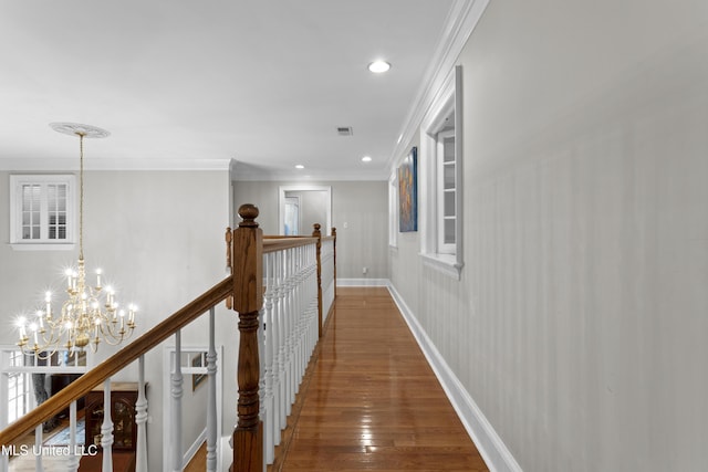 hallway featuring crown molding, dark hardwood / wood-style flooring, and a notable chandelier