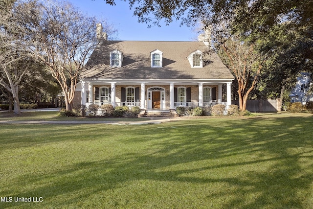 cape cod house with a front lawn and covered porch