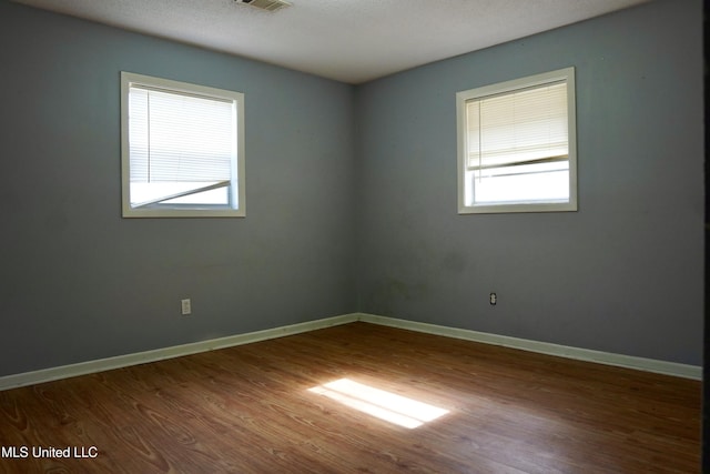 unfurnished room featuring hardwood / wood-style floors and a textured ceiling