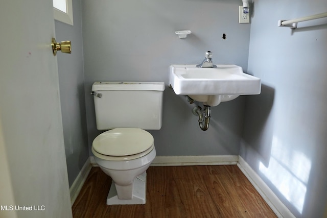 bathroom featuring wood-type flooring, toilet, and sink