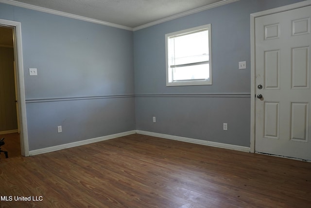 empty room with crown molding and dark hardwood / wood-style floors