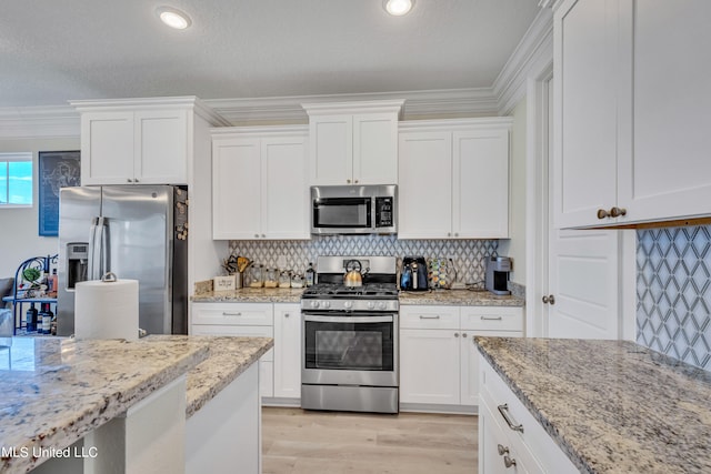 kitchen featuring appliances with stainless steel finishes, crown molding, white cabinetry, and light wood-type flooring