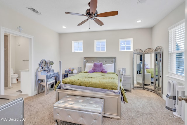 bedroom with light carpet, ensuite bathroom, and ceiling fan