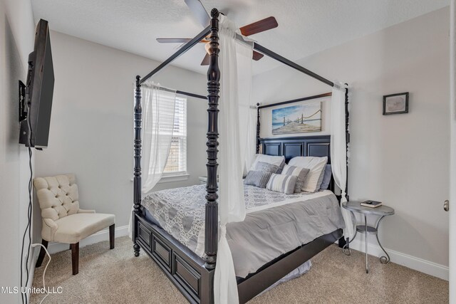 bedroom featuring light carpet, a textured ceiling, and ceiling fan