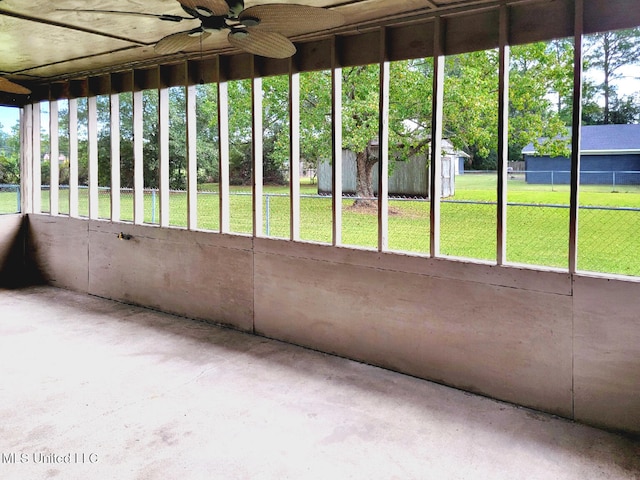 unfurnished sunroom featuring ceiling fan