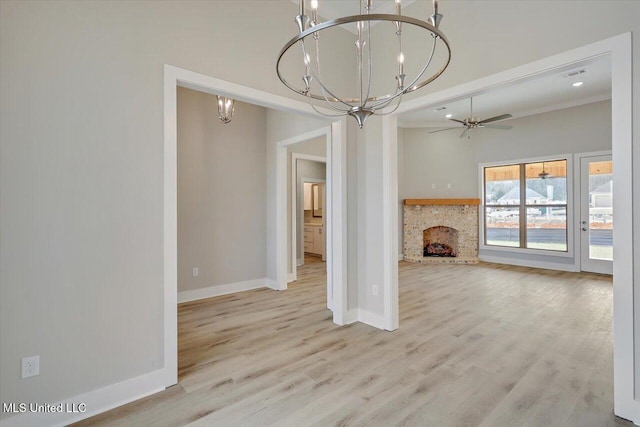 unfurnished living room with a notable chandelier, a fireplace, baseboards, wood finished floors, and visible vents