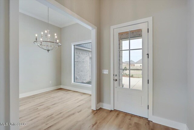 entryway with baseboards, wood finished floors, and a notable chandelier