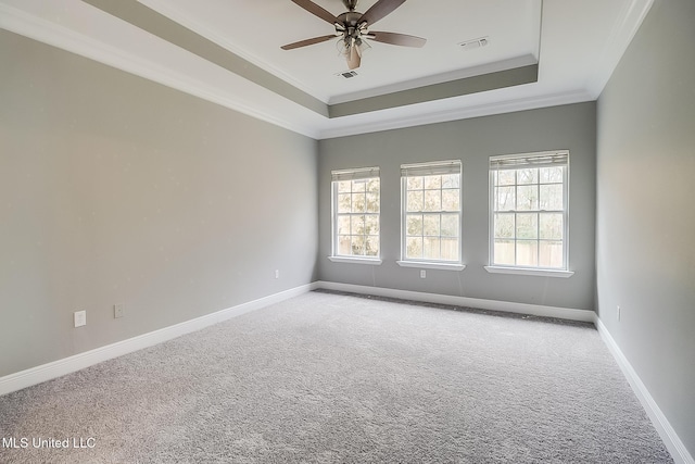 carpeted empty room featuring crown molding, a tray ceiling, and ceiling fan