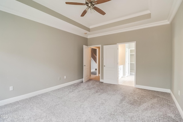 unfurnished bedroom with crown molding, light colored carpet, a raised ceiling, and ceiling fan