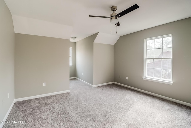 unfurnished room with vaulted ceiling, light colored carpet, and ceiling fan