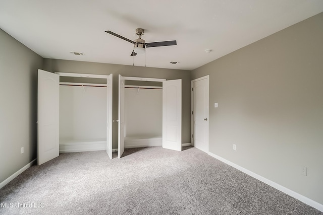 unfurnished bedroom with multiple closets, ceiling fan, and carpet