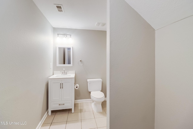 bathroom with tile patterned flooring, vanity, and toilet