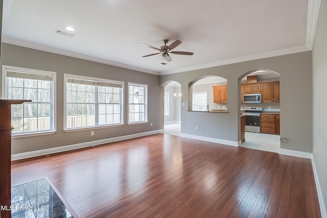 unfurnished living room with ornamental molding, a healthy amount of sunlight, and light wood-type flooring