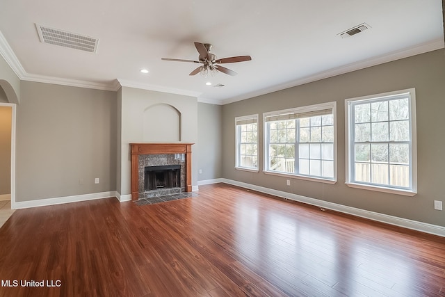 unfurnished living room with hardwood / wood-style floors, crown molding, and a healthy amount of sunlight