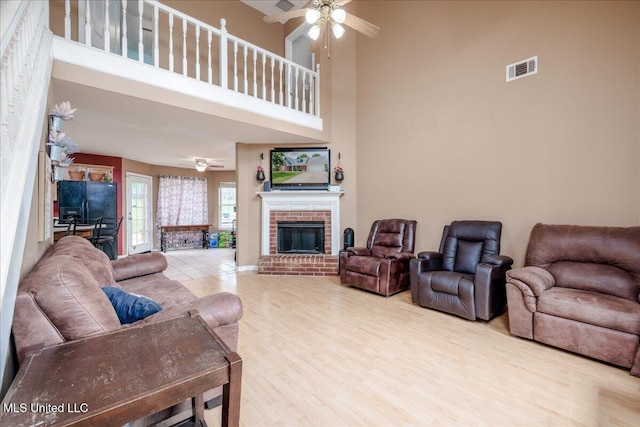1826 Towson Ln, Horn Lake, MS 38637 - living room with a ceiling fan, a towering ceiling, wood finished floors, and a brick fireplace