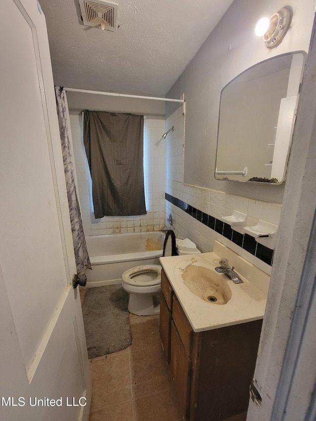 bathroom featuring vanity, toilet, tile patterned floors, a textured ceiling, and visible vents