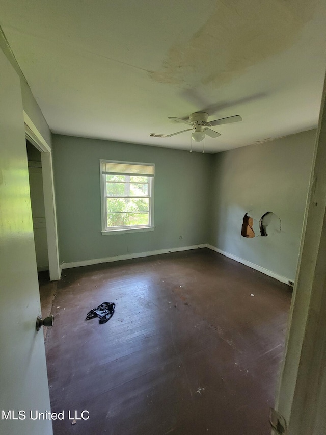 spare room with baseboards, ceiling fan, concrete flooring, and visible vents