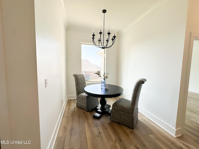 dining room featuring ornamental molding, a chandelier, and hardwood / wood-style floors