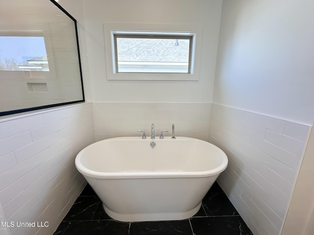 bathroom featuring tile walls and a tub to relax in