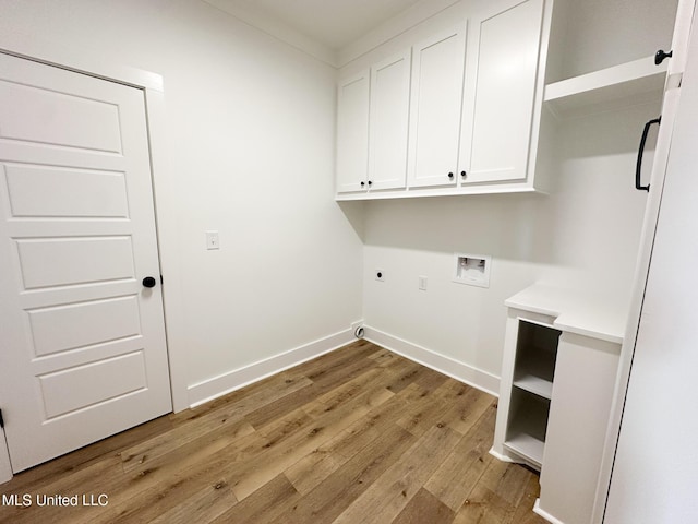 laundry room with electric dryer hookup, hookup for a washing machine, light hardwood / wood-style floors, and cabinets