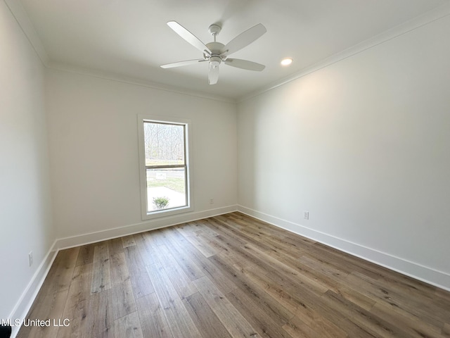 spare room with hardwood / wood-style floors, crown molding, and ceiling fan