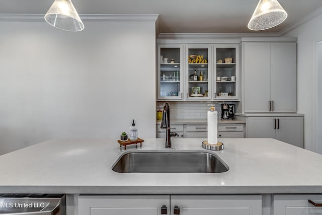 kitchen featuring pendant lighting, sink, ornamental molding, decorative backsplash, and stainless steel dishwasher