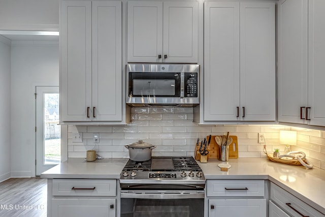 kitchen with tasteful backsplash, stainless steel appliances, and white cabinets