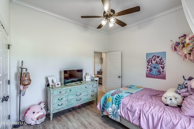 bedroom featuring wood-type flooring, ornamental molding, and ceiling fan