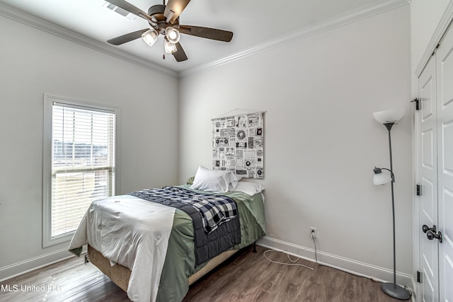 bedroom featuring dark hardwood / wood-style flooring, ornamental molding, and ceiling fan