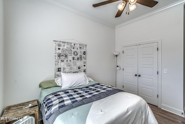 bedroom featuring crown molding, dark wood-type flooring, a closet, and ceiling fan