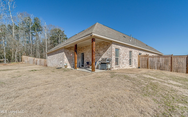 back of property featuring a patio and a lawn