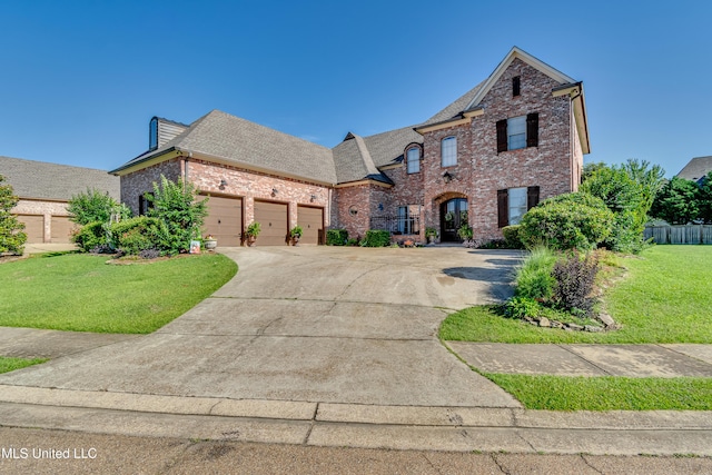 521 Heyward Ln, Madison, MS 39110 - french country home featuring brick siding, roof with shingles, a front yard, a garage, and concrete driveway